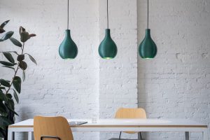 green lamps avobe a dining table
