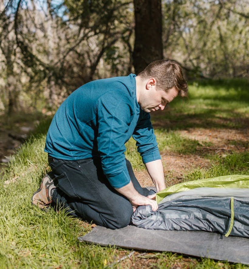 a man folding his tent