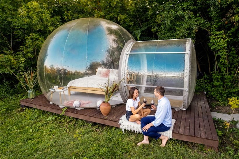 couple drinking wine in front of a cabin