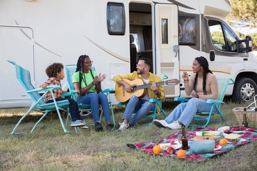a group of friends singing in front of a campervan