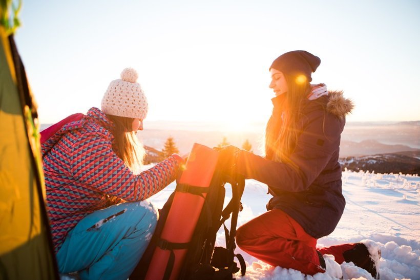 two girls arranging winter camping gear