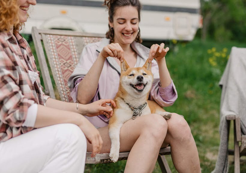 a woman holding a dog's ears