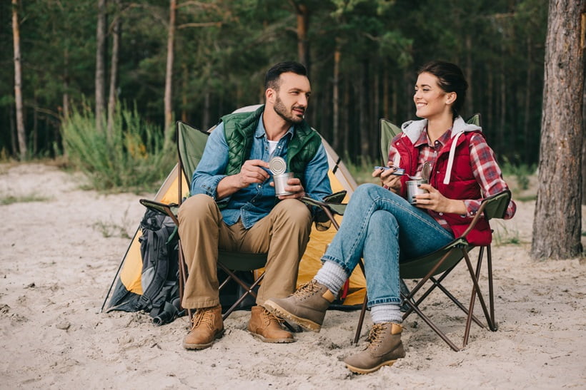 couple eating canned food during camping