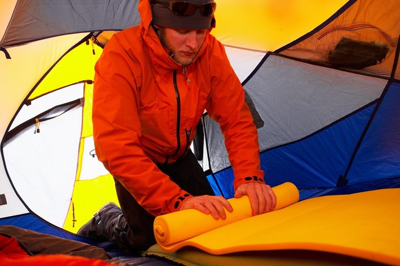 a man folding his sleeping pad