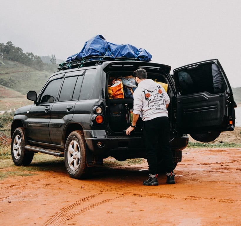a man loading camping gear into his car