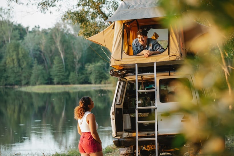 couple talking near lake while camping