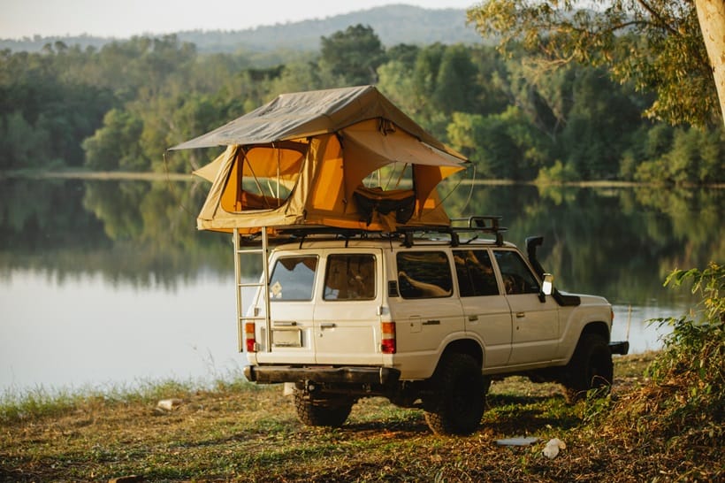 a 4x4 vehicle is parked near a lake
