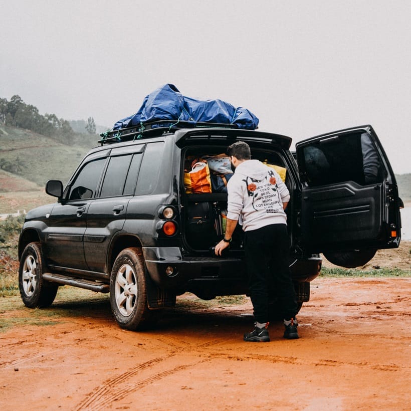 a man organizing his car trunk for camping