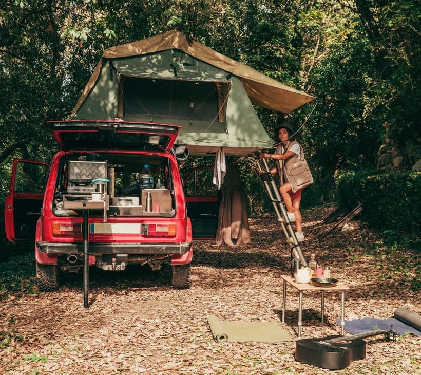 a woman climbing letter to reach her tent
