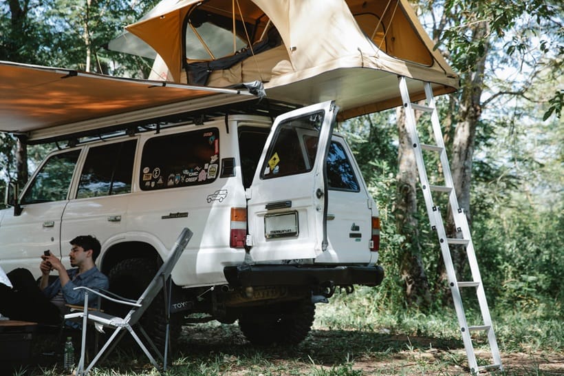 a van parked in a forest for camping