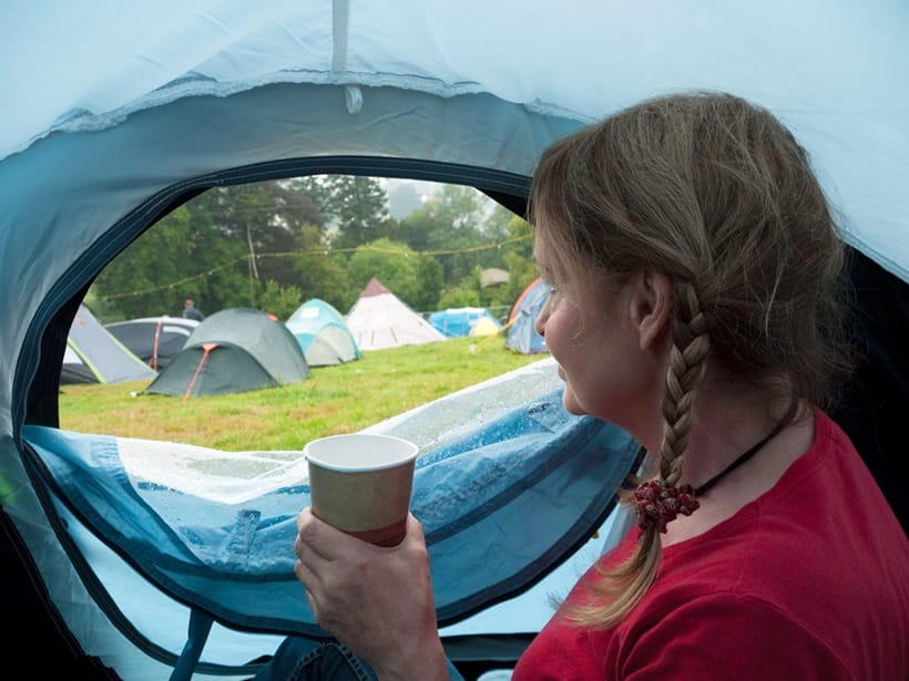 a camper drinking coffee in tent