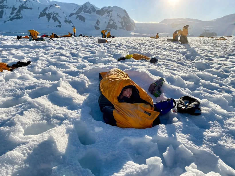 woman burried under snow in a sleeping bag