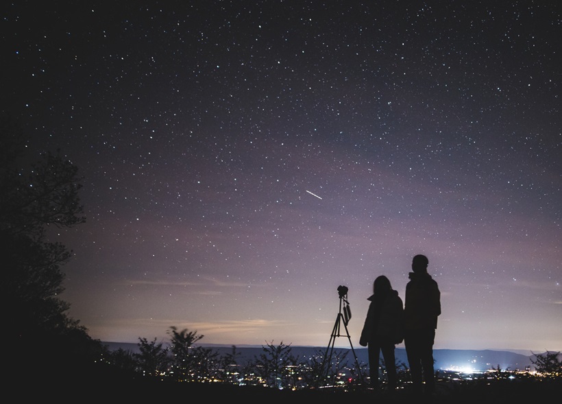 a couple in a deserted area to watch the dark sky