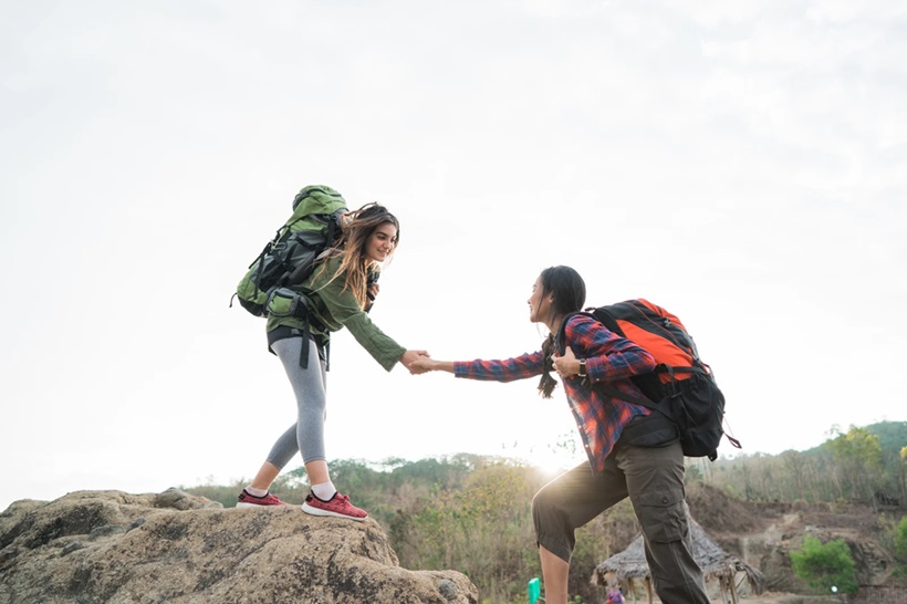 a woman helping another backpacker